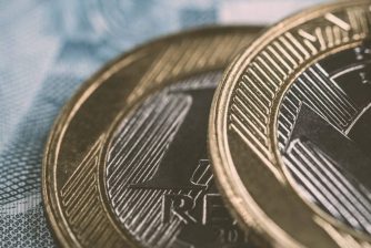 Brazilian real coins, with golden tone. Banking savings or investment concept. Coins a real selective focus.